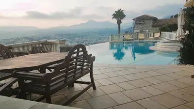 a table and chairs next to a swimming pool at Roc Maria Lucia in Nice