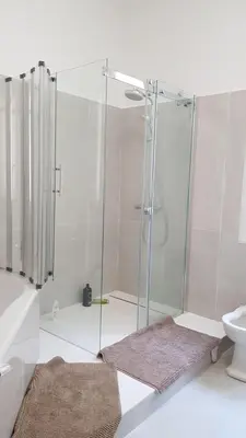 a bathroom with a shower with two mats on the floor at Roc Maria Lucia in Nice