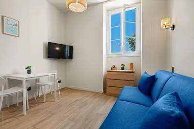 a living room with a blue couch and a table at Residence Massena in Nice