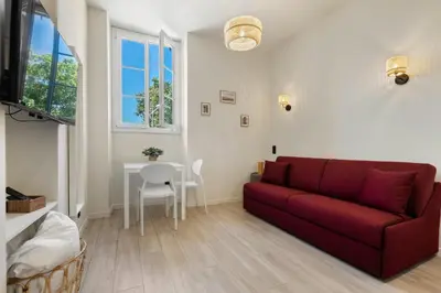 a living room with a red couch and a table at Residence Massena in Nice