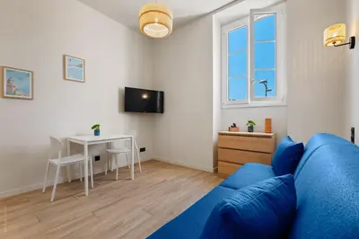 a living room with a blue couch and a table at Residence Massena in Nice