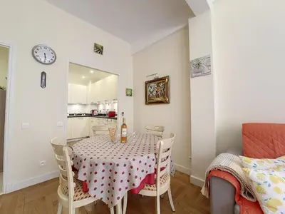 a dining room with a table and chairs and a clock at Nestor&Jeeves - BEAUSOLEIL - Central - tres proche mer in Nice
