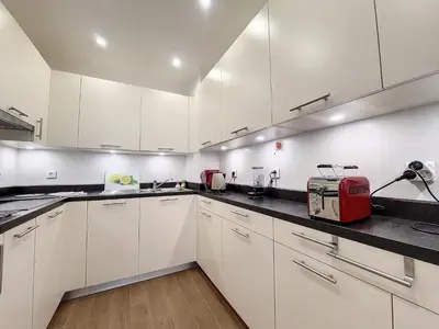 a kitchen with white cabinets and a red appliance at Nestor&Jeeves - BEAUSOLEIL - Central - tres proche mer in Nice