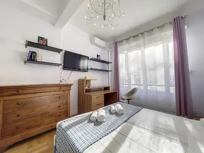 a bedroom with a bed with a dresser and a tv at Nestor&Jeeves - BEAUSOLEIL - Central - tres proche mer in Nice