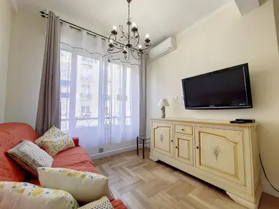 a living room with a tv and a red couch at Nestor&Jeeves - BEAUSOLEIL - Central - tres proche mer in Nice