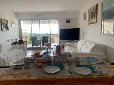 a living room with a table with plates and utensils at Front sea Luxury in Cagnes-sur-Mer