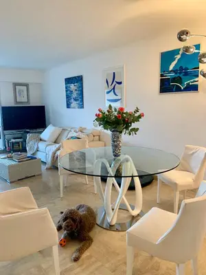 a living room with a glass table and a dog laying on the floor at Front sea Luxury in Cagnes-sur-Mer