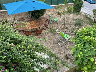 a table and chairs and an umbrella in a garden at appartement nice in Nice
