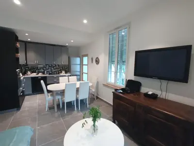 a large living room with a table and a tv at appartement nice in Nice