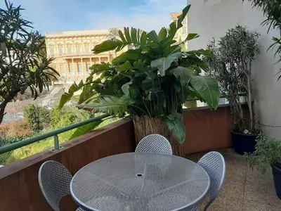 a table and chairs on a balcony with a plant at studio joli in Nice