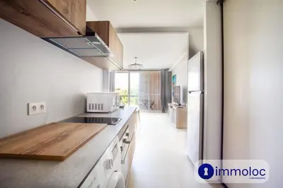 a kitchen with a stove top oven next to a refrigerator at Air-conditioned studio 5 minutes from the beach and shops in Cros-de-Cagnes
