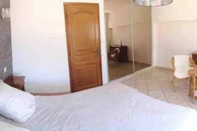 a bedroom with a large white bed and a chair at Villa avec piscine et vue magnifique sur Nice in Nice