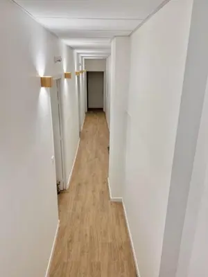 an empty hallway with white walls and wood floors at Résidence Petite Californie in Nice