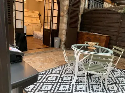 a table and two chairs in a room with a floor at Appartement 1pièce avec jardin dans Mas de Caractère in Saint-Laurent-du-Var