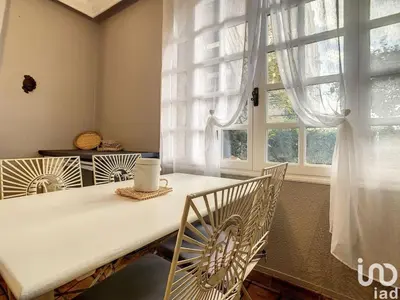 a dining room with a table and chairs and a window at Appartement 1pièce avec jardin dans Mas de Caractère in Saint-Laurent-du-Var