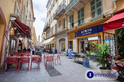 a living room with a table and a kitchen at Air-conditioned apartment in Old Nice in Nice