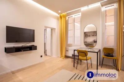 a living room with a table and chairs and a television at Air-conditioned apartment in Old Nice in Nice
