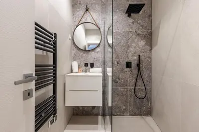 a bathroom with a shower and a sink and a mirror at Charming Central 1 Bdr in Nice