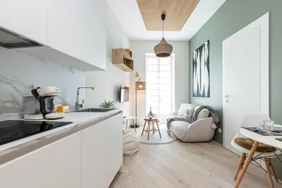 a kitchen with white countertops and a living room at Charming Central 1 Bdr in Nice