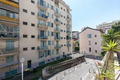an apartment building with a palm tree in front of it at 1 Bdr Large Terrace in Nice