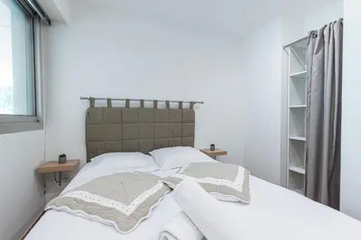 a bedroom with a bed with white sheets and pillows at 1 Bdr Large Terrace in Nice