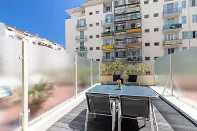 a table and chairs on a balcony with a building at 1 Bdr Large Terrace in Nice