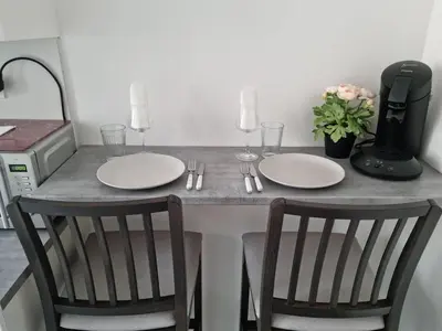 a table with two white plates and two chairs at Appartement 2 pieces in Nice