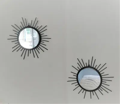 a mirror with a sunburst mirror on a wall at Appartement 110m2 Nice plein centre in Nice