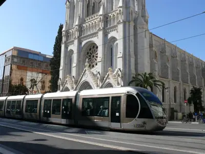 a train in front of a building with a church at Appartement 110m2 Nice plein centre in Nice