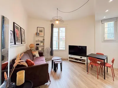a living room with a couch and a television at Cosy 2 pieces rénové, Proche mer, 4 pers in Nice