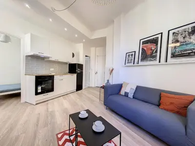 a living room with a blue couch and a table at Cosy 2 pieces rénové, Proche mer, 4 pers in Nice
