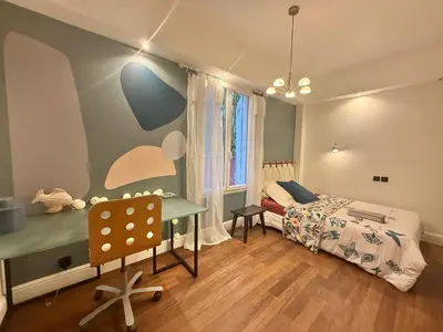 a bedroom with a bed and a desk and a table at Souvenir à jamais ! in Nice