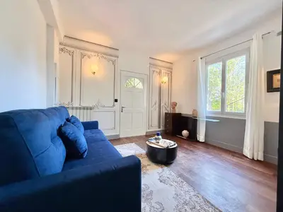 a living room with a blue couch and a large window at Souvenir à jamais ! in Nice