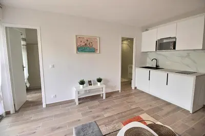 a kitchen with white cabinets and a table at Cosy appartement en plein coeur de la libération in Nice