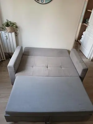 a gray couch in a living room next to a wall at BEAUTIFUL apartment , beach 3 min walk , free parking, near Negresco in Nice