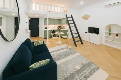 a living room with a blue couch and a table at Studio élégant 4 couchages Front de Mer clim Parking privatif Wifi in Nice