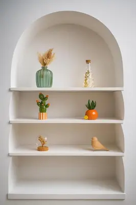 a white shelf with vases and plants on it at Studio élégant 4 couchages Front de Mer clim Parking privatif Wifi in Nice