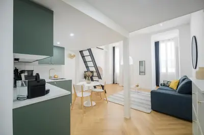 a kitchen and a living room with a blue couch at Studio élégant 4 couchages Front de Mer clim Parking privatif Wifi in Nice