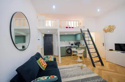 a living room with a couch and a mirror at Studio élégant 4 couchages Front de Mer clim Parking privatif Wifi in Nice