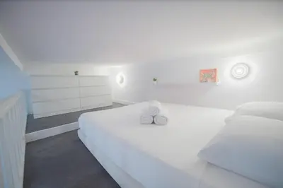 a white bedroom with a white bed and white cabinets at Studio élégant 4 couchages Front de Mer clim Parking privatif Wifi in Nice