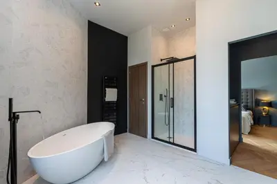 a white bath tub in a bathroom with a bedroom at MY CASA - HSAUVAN - Villa Design Swimming Pool Sea View in Saint-Jean-Cap-Ferrat