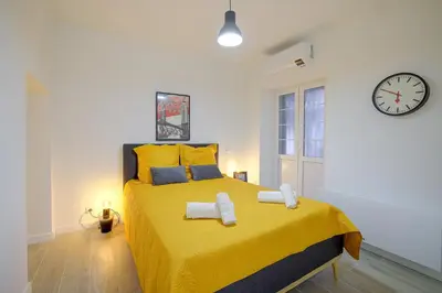 a bedroom with a yellow bed with towels on it at Maison Bianchi - Jaures Old Town in Nice