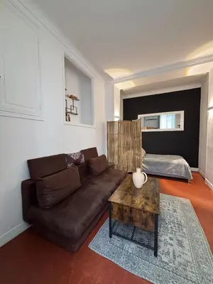 a living room with a brown couch and a table at Studio Au coeur de Nice in Nice