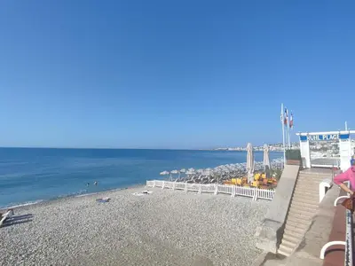 a person sitting on a bench on the beach at Studio Au coeur de Nice in Nice