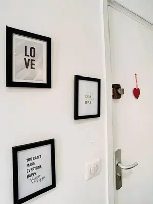 two framed pictures on a wall next to a door at Appartement Terrasse Proche Port et Plages de Nice in Nice