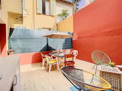 a patio with a table and chairs and an umbrella at Appartement Terrasse Proche Port et Plages de Nice in Nice