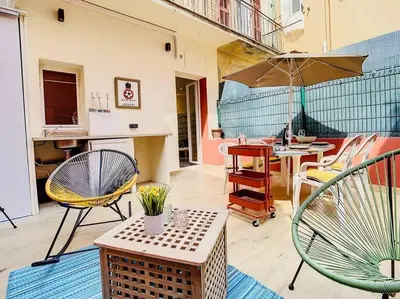 a patio with chairs and a table with an umbrella at Appartement Terrasse Proche Port et Plages de Nice in Nice