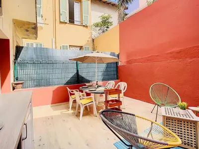 a patio with a table and chairs and an umbrella at Appartement Terrasse Proche Port et Plages de Nice in Nice