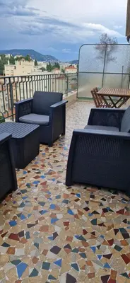 a patio with chairs and tables on a mosaic floor at NICE STUDIO 26m2 avec TERRASSE 16m2 in Nice
