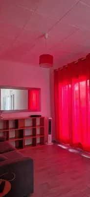 a living room with red lighting and red curtains at NICE STUDIO 26m2 avec TERRASSE 16m2 in Nice